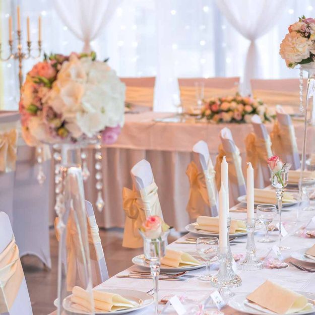 Beautiful wedding tables and chairs with polyester table linen on rectangle guest tables.